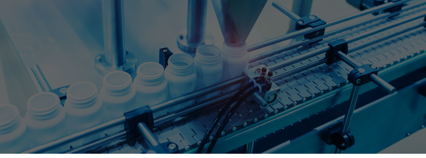 A machine produces bottles on a conveyor belt, showcasing an automated manufacturing process in action