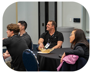 A diverse group of people seated around a table engaged in conversation