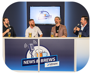 At a table, men converse while a microphone and a beer are present, creating a relaxed atmosphere