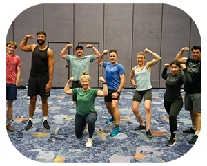 A cheerful group of gym-goers poses for a photo