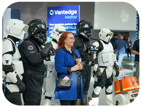 A woman stands among a group of robots