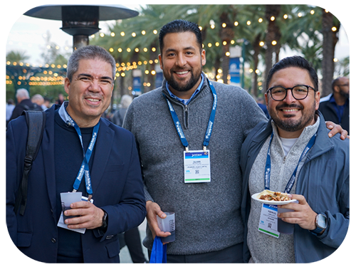  Three smiling men hold plates of food, enjoying a meal together in a cheerful setting