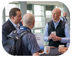 Three men engaged in conversation at networking breakfast