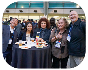 A diverse group of people smiling and posing together for a photo at MD&M West