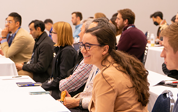  A diverse group of individuals engaged in discussion around a conference table in a professional setting.