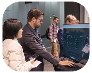 A man and woman stand together in front of a large screen photo