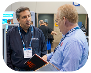 Two men engaged in conversation at a bustling trade show