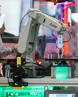 Two men in suits observe a robot, engaged in discussion about its features and capabilities