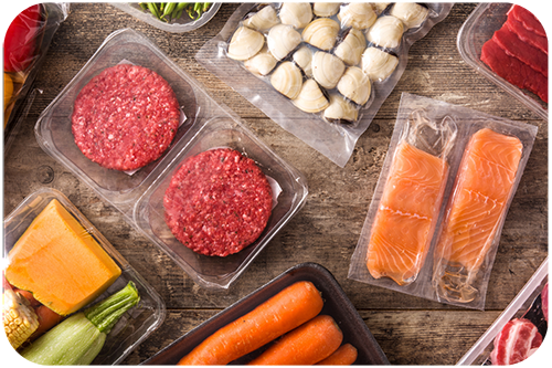 Assorted meats and vegetables arranged in clear plastic containers on a white background