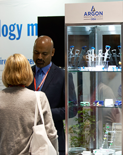 A man and woman stand together in front of a glass display case, examining the items inside