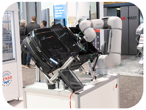A futuristic robot exhibited at a trade show, attracting attention from visitors interested in robotics
