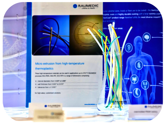 A vase of plastics alongside a poster, with conference attendees engaged in a presentation taking place on stage