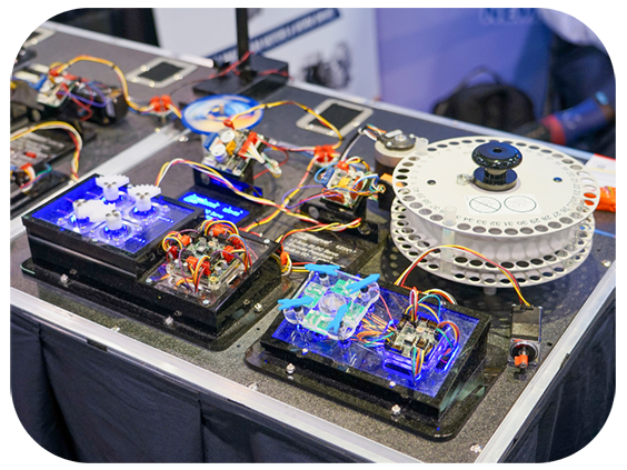 A tabletop filled with assorted electronic devices and wires, illustrating a busy tech environment